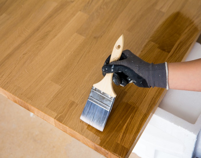 Person applying oil to a kitchen countertop