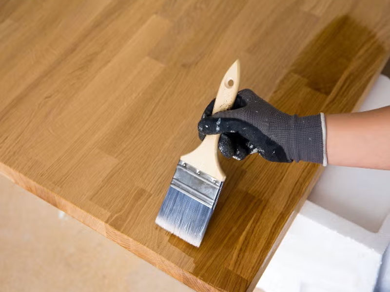 Person applying oil to a kitchen countertop